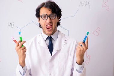Beyaz tahta önünde genç komik kimyager 