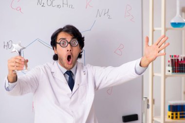 Beyaz tahta önünde genç komik kimyager 
