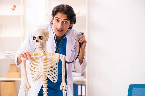 Jovem médico masculino com esqueleto — Fotografia de Stock