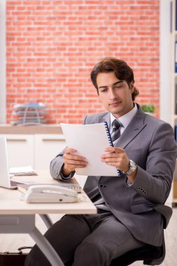 Ofiste çalışan genç bir işadamı.