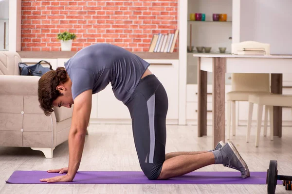 Junger schöner Mann beim Sport zu Hause — Stockfoto