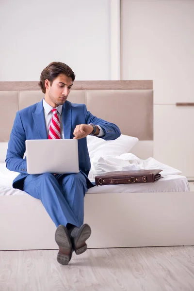 Junge Angestellte, die zu Hause auf dem Bett sitzt — Stockfoto