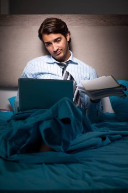 Yorgun işadamı gece fazla mesai yapıyor.