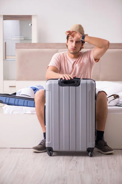 Мужчина с чемоданом в спальне ждет поездки — стоковое фото