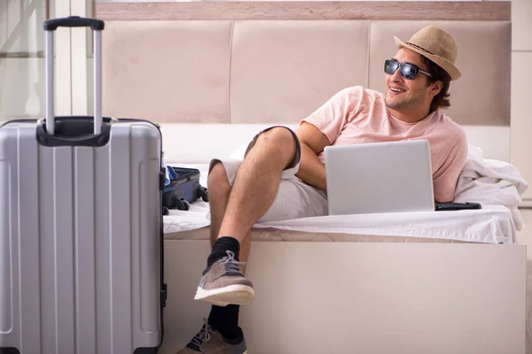 Muž s kufrem v ložnici čeká na výlet — Stock fotografie