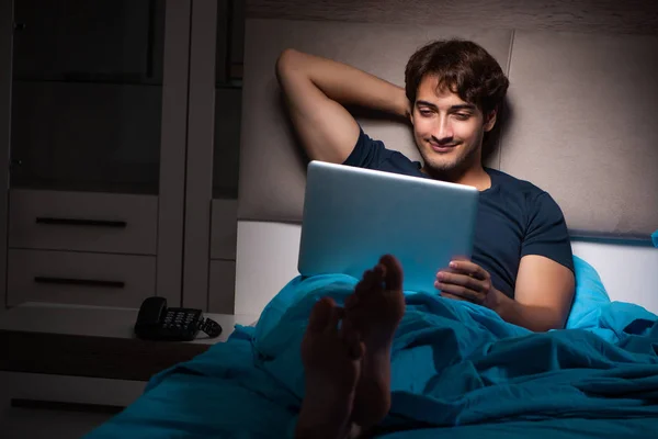 Gece yatakta dizüstü bilgisayarda çalışan adam — Stok fotoğraf