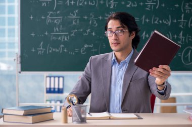 Genç yakışıklı matematik öğretmeni sınıfta 