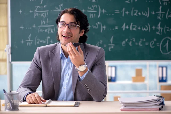 Молодой красивый учитель математики в классе — стоковое фото