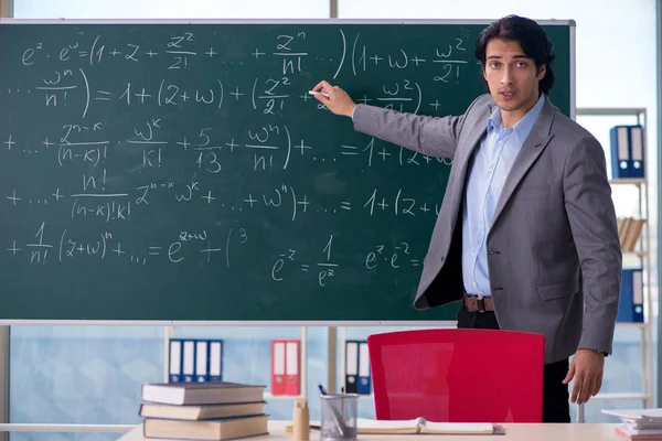 Genç yakışıklı matematik öğretmeni sınıfta 