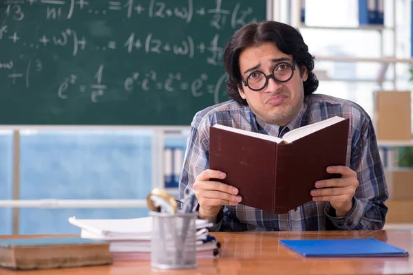 Joven profesor de matemáticas divertido delante de pizarra — Foto de Stock