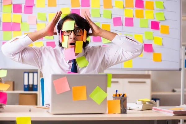 Young employee in conflicting priorities concept — Stock Photo, Image