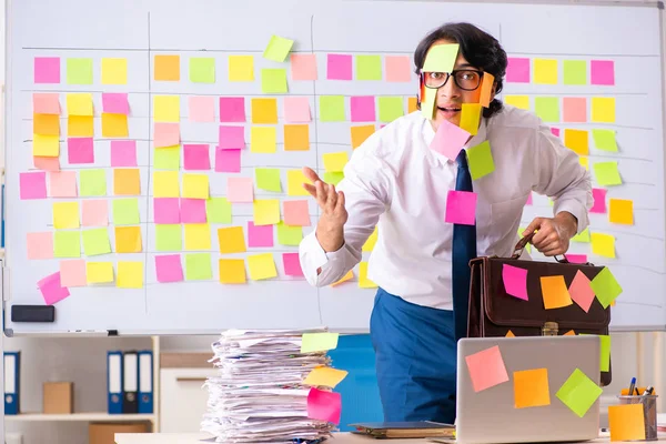 Junger Mitarbeiter in widersprüchlichem Prioritätenkonzept — Stockfoto