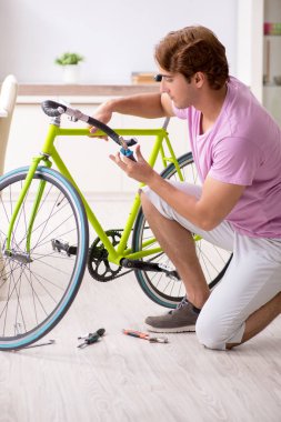 Kırık bisikletini tamir eden adam.