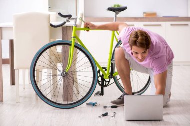 Kırık bisikletini tamir eden adam.