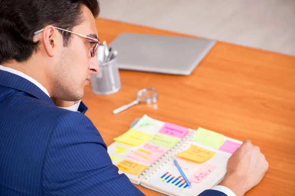 Junger schöner Mitarbeiter plant seine Arbeitstätigkeit — Stockfoto