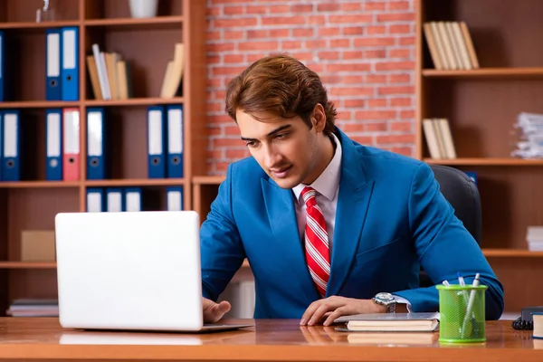 Jeune beau employé assis dans le bureau — Photo