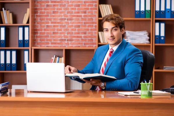 Jovem e bonito empregado sentado no escritório — Fotografia de Stock