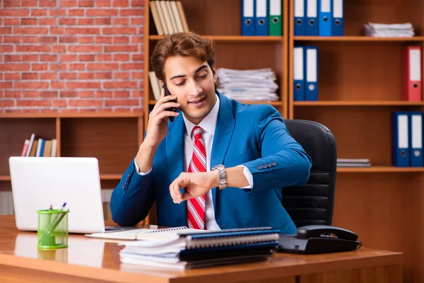 Joven empleado guapo sentado en la oficina — Foto de Stock