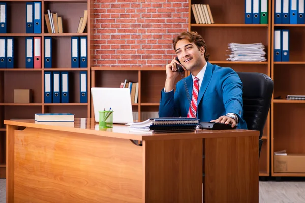 Joven empleado guapo sentado en la oficina —  Fotos de Stock