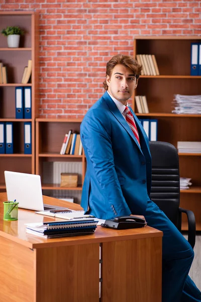 Joven empleado guapo sentado en la oficina —  Fotos de Stock