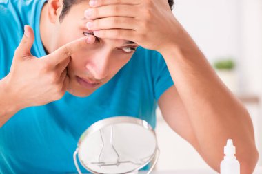 Evde kontak lensleri deneyen adam