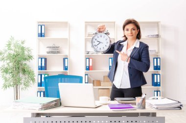 Ofiste oturan orta yaşlı kadın işçiye  