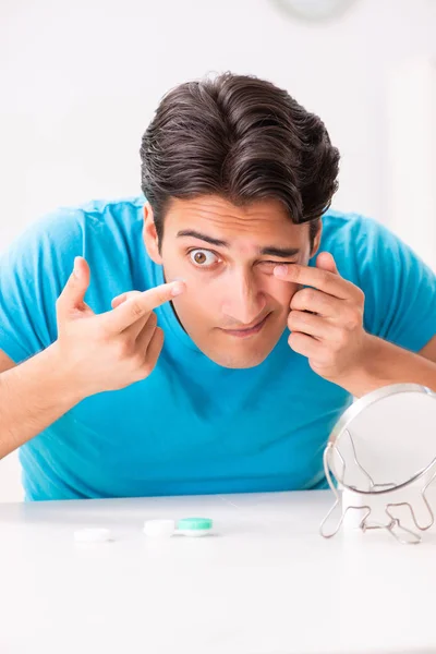 Homem tentando lentes de contato em casa — Fotografia de Stock