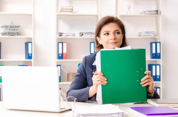 Employée d'âge moyen assise au bureau — Photo