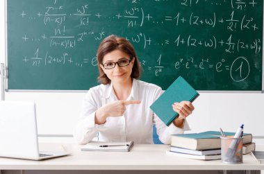 Kara tahta önünde kadın matematik öğretmeni 
