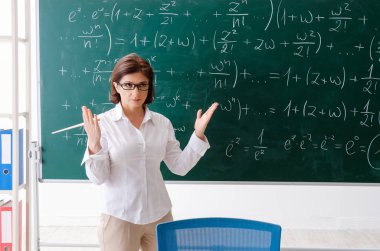 Kara tahta önünde kadın matematik öğretmeni 