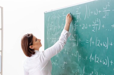 Kara tahta önünde kadın matematik öğretmeni 