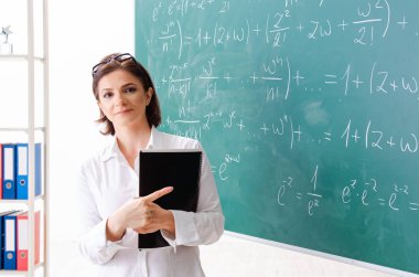 Kara tahta önünde kadın matematik öğretmeni 