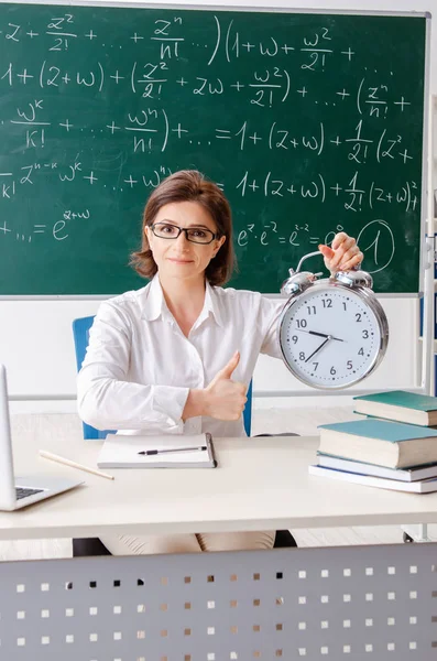 Vrouwelijke wiskundeleraar tegenover het schoolbord — Stockfoto