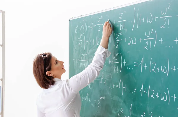 Female math teacher in front of the chalkboard — Stock Photo, Image