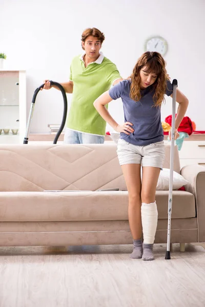 Man helpen been gewonde vrouw in huishoudelijk werk — Stockfoto