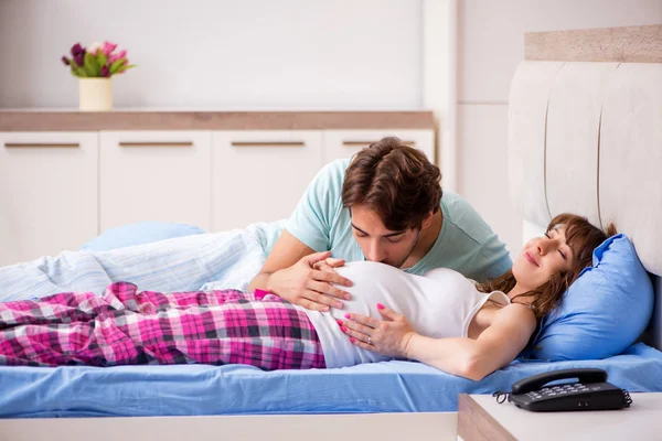 Schwangere mit Ehemann im Schlafzimmer — Stockfoto