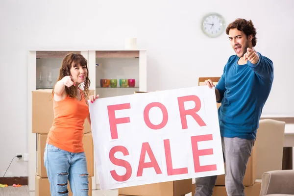 Joven familia ofreciendo casa para la venta y mudanza — Foto de Stock