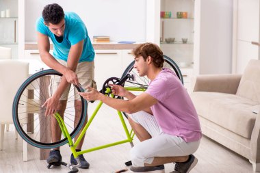 Kırık bisikletini tamir eden adam.