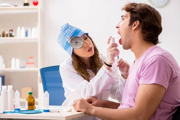 Young handsome man visiting young female doctor otolaryngologist — Stock Photo, Image