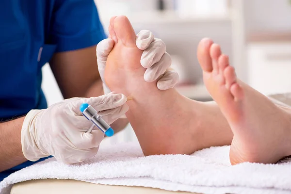 Podólogo tratando los pies durante el procedimiento — Foto de Stock