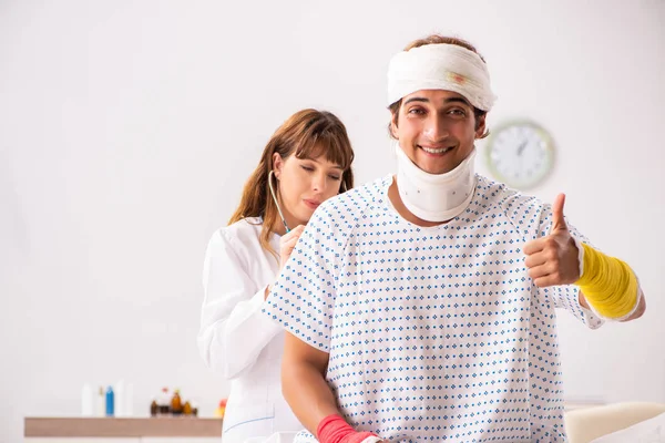 Ung läkare undersöker skadad patient — Stockfoto