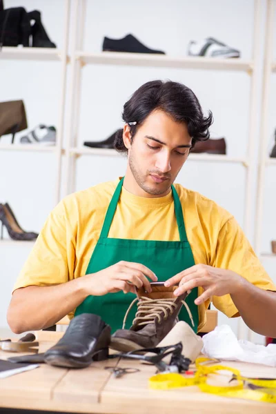Joven reparando zapatos en taller — Foto de Stock