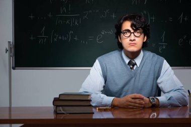 Kara tahta önünde genç matematik öğretmeni