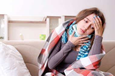 Sick young woman suffering at home  clipart