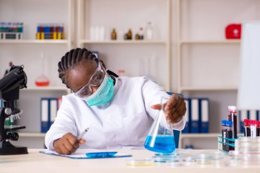 Laboratuarda çalışan genç siyah kimyager 