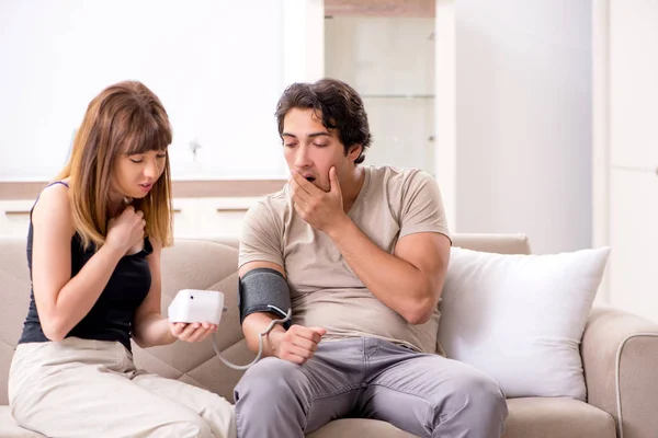Ehefrau überprüft Blutdruck ihrer Ehemänner — Stockfoto