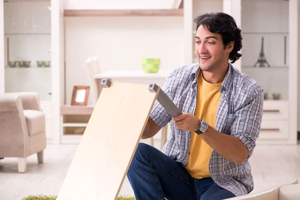 Young handsome man repairing chair at home — Stock Photo, Image