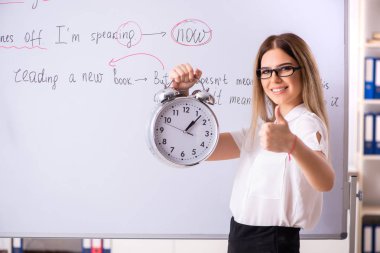 B önünde duran genç kadın İngilizce öğretmeni