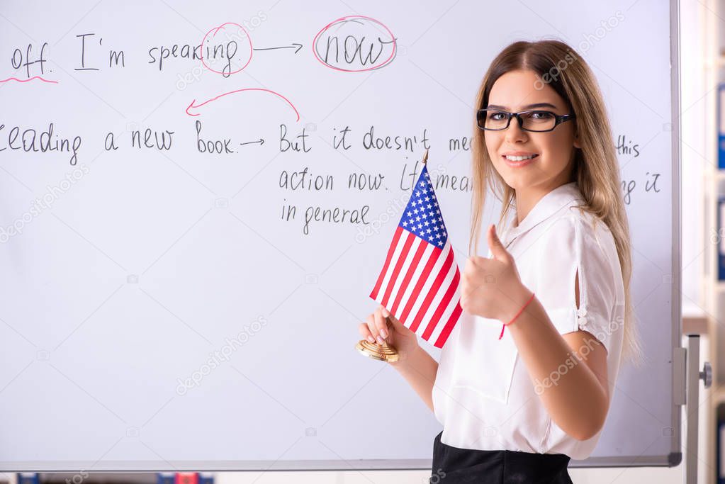 Young female english language teacher standing in front of the b