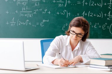 Kara tahta önünde kadın matematik öğretmeni 